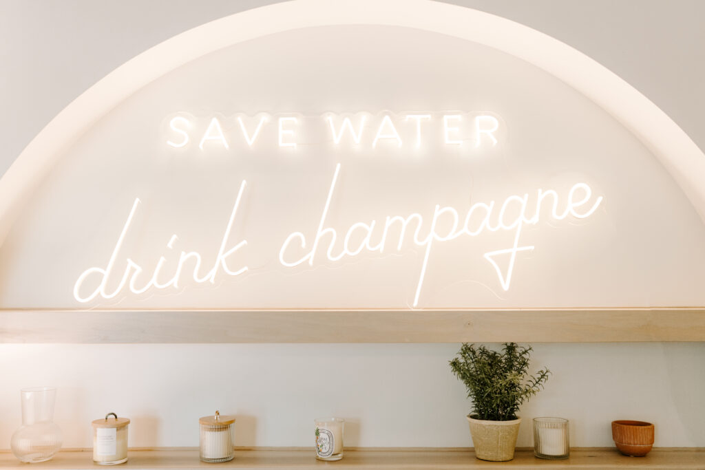 Save water drink champagne neon sign in the bridal suite at Willow on Grand.